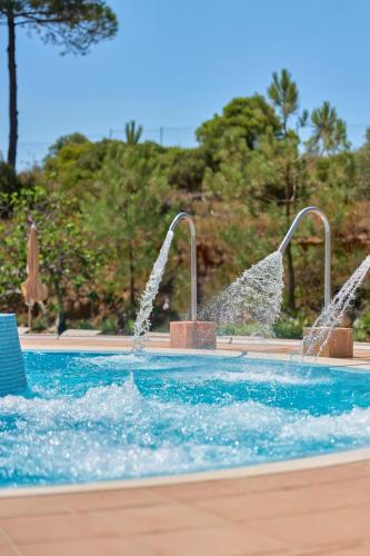 a pool with two water fountains in a resort at PortoBay Blue Ocean in Albufeira