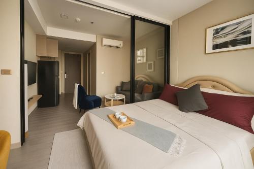 a hotel room with a bed with a tray on it at The One Luxury Condo - Asoke Bangkok in Bangkok