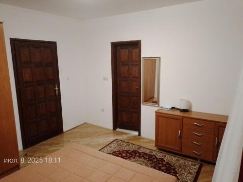 an empty room with two doors and a dresser at Guest House SAM-WATER in Ðenovići