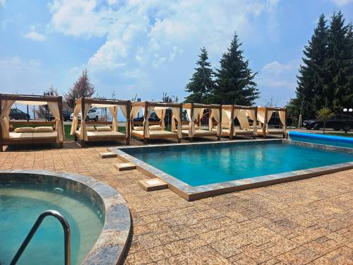 a large swimming pool with chairs around it at Residence Hill Lux in Kopaonik