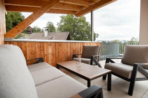 a patio with two chairs and a table on a deck at OpenSky Wörthersee Lodge in Pörtschach am Wörthersee