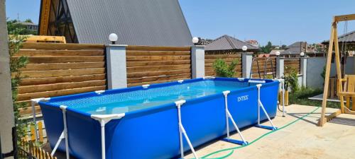 a blue pool in front of a wooden fence at A-frame evlər in Qusar