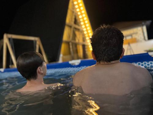 two young boys are swimming in a pool at A-frame evlər in Qusar