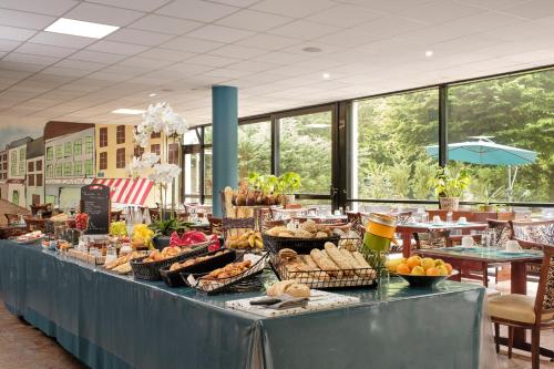 a buffet with bread and other food on a table at Hôtel Marso in Amnéville