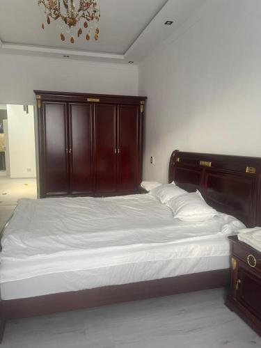 a large bed with a wooden headboard in a bedroom at Palace Apartament in Dushanbe