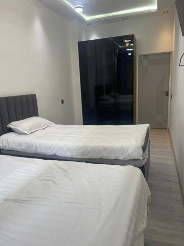 two twin beds in a room with a mirror at Palace Apartament in Dushanbe