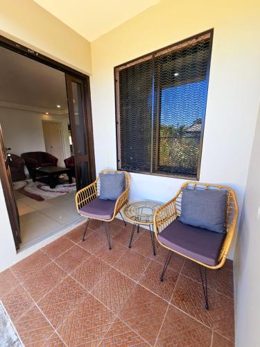 two chairs and a table in a room at Aurora Apartments near Nadi International Airport in Nadi International Airport