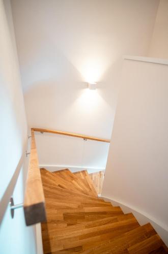 a room with a staircase with a light and wooden floor at OpenSky Wörthersee Lodge in Pörtschach am Wörthersee
