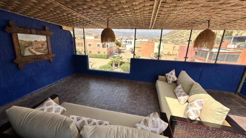 a living room with a couch and some windows at Duplex imiouaddar in Imi Ouaddar
