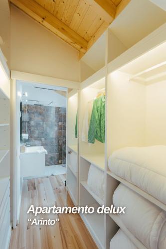 a bedroom with a bathroom with a bed and a sink at Alojamentos Plansel - No Coração das Vinhas do Alentejo in Montemor-o-Novo