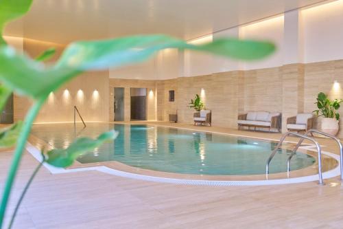 a swimming pool in a hotel with chairs and a couch at PortoBay Blue Ocean in Albufeira