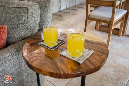 two glasses of orange juice sitting on a wooden table at 2BR bright quiet condo in Kulalani sleeps 6 in Waikoloa
