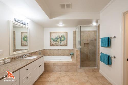 a bathroom with a tub and a sink and a shower at 2BR bright quiet condo in Kulalani sleeps 6 in Waikoloa