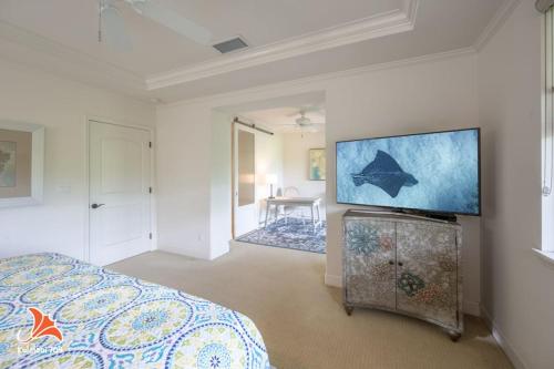 a bedroom with a bed and a flat screen tv at 2BR bright quiet condo in Kulalani sleeps 6 in Waikoloa