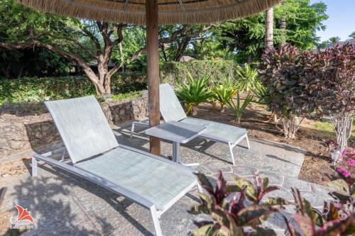two chairs and a table under an umbrella at 2BR bright quiet condo in Kulalani sleeps 6 in Waikoloa