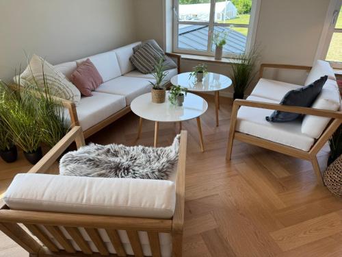 a living room with a couch and two tables at Bramslev Bakker Naturhotel in Hobro