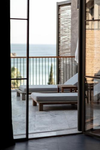 a balcony with two beds and a view of the ocean at Club Marvy in Ozdere