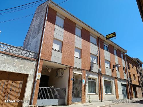 an old brick building with a street sign on it at Hostal Restaurante Yagual in Sahagún