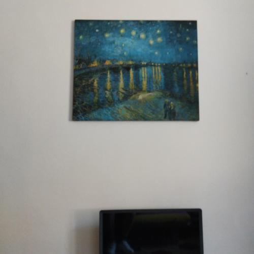 a painting hanging on a wall next to a fireplace at camera vacanza in Celle Ligure