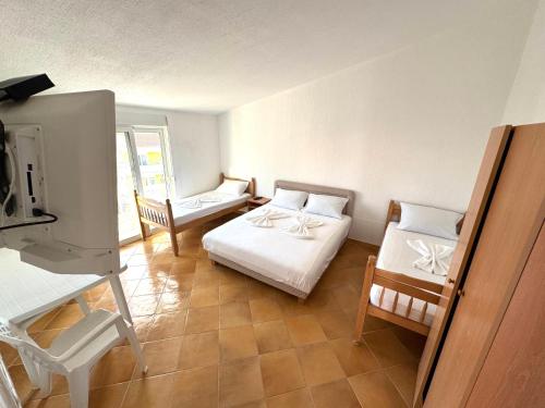 a room with two beds and a table and chairs at ADO Apartmani Ulcinj Velika Plaza Donji Stoj in Donji Štoj