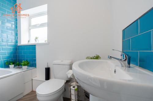 a bathroom with a white toilet and a sink at 9 Guests, 4 Bedrooms, Modern Comfort in Bootle in Litherland