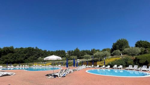 a group of chairs and umbrellas in a pool at Wendy House RESIDENCE CORTE COLLINA in Castion Veronese