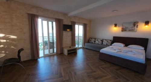 a bedroom with a bed and a couch in it at Captain's View in Dobra Voda