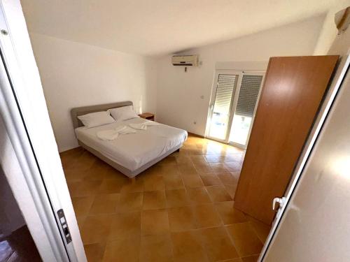 a bedroom with a bed and a tiled floor at ADO Apartmani Ulcinj Velika Plaza Donji Stoj in Donji Štoj
