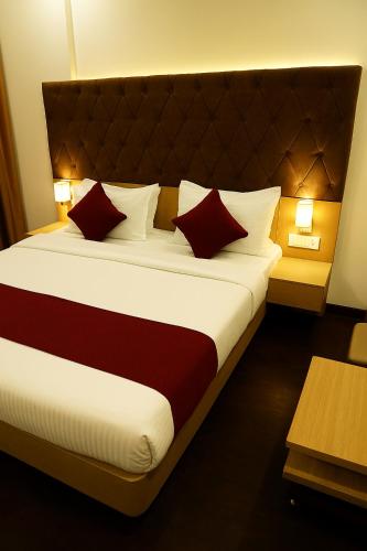 ボーパールにあるHotel Partinidhi Staysのベッドルーム1室(大型ベッド1台、赤と白の枕付)