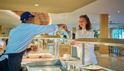 a man and a woman preparing food in a kitchen at PortoBay Blue Ocean in Albufeira