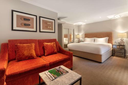 a hotel room with a bed and a couch at Guild Hotel Marble Arch in London