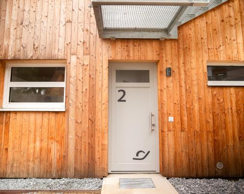 a wooden building with a white door and two windows at OpenSky Wörthersee Lodge in Pörtschach am Wörthersee