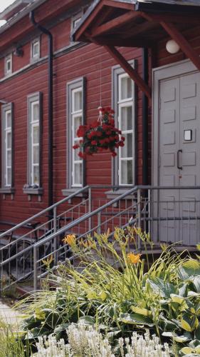 a red house with a flower basket in front of it at Hostelli Marja in Mikkeli