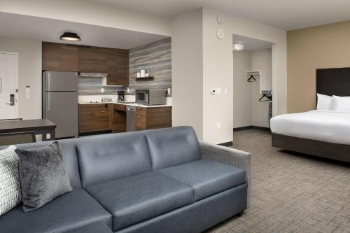 a living room with a couch and a bedroom at Residence Inn Doral Mall Area in Doral