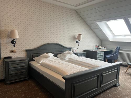 a bedroom with a bed and a desk and a window at Hotel Ochsen in Höfen an der Enz