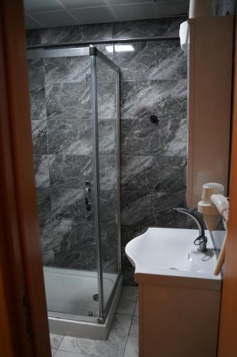 a shower with a glass door next to a sink at Turk Art Hotel in Istanbul