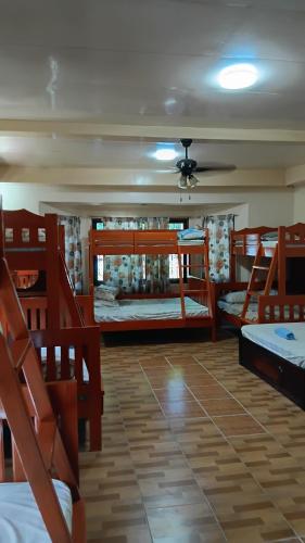 a room with four bunk beds and a ceiling at Jovick Homestay in Siquijor