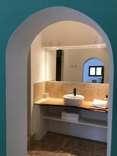 een badkamer met een wastafel en een spiegel bij Les Bosquets in Lorgues