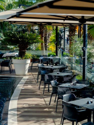 a restaurant with tables and chairs and a pool at Gloria Palace Hotel & SPA in Golem