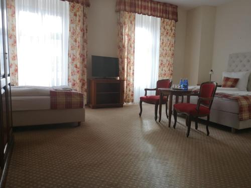 a hotel room with a bed and a table and chairs at Pałac Brunów - Wellness & SPA in Lwówek Śląski