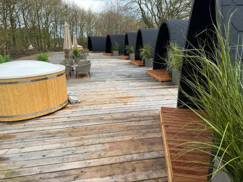 a wooden walkway with benches and plants on it at Bramslev Bakker Naturhotel in Hobro