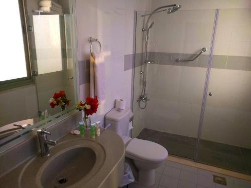 a bathroom with a sink and a shower with a toilet at City Inn Palace Hotel in Ramallah