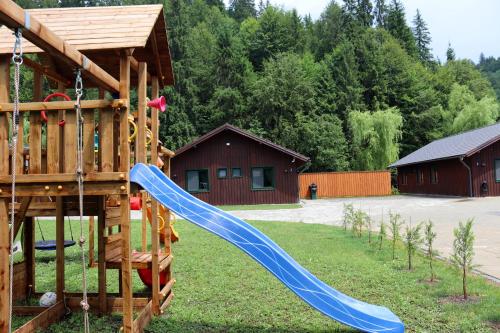 a playground with a blue slide in a yard at Varsag Resort in Vărşag