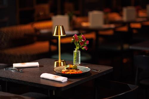 a plate of food on a table with a lamp at Boscolo Lyon Hotel & Spa in Lyon
