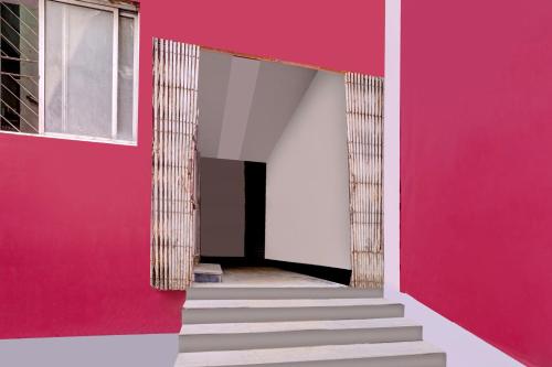 a hallway with pink and white walls and stairs at Hotel O LAXMI GUEST HOUSE in Rānchī