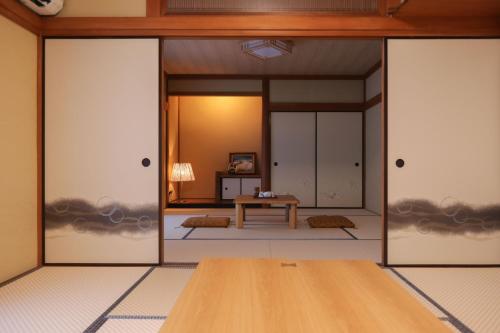 a room with doors open to a room with a table at 1日1組限定まるまる貸切ゆったり楽しもう駐車場3台無料Limited to one group per dayEnjoy the entire space with your family Parking for 3 cars in Hakone