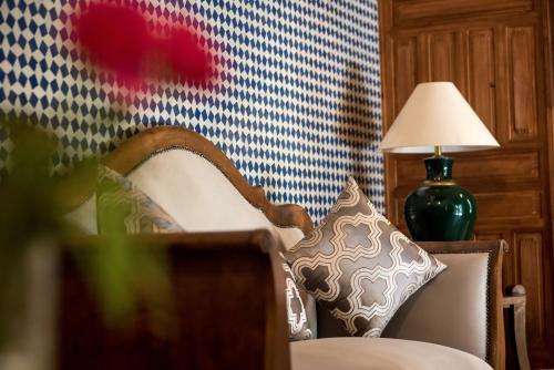 a chair with a pillow and a lamp in a room at Riad Hanael Garden & Spa in Fès