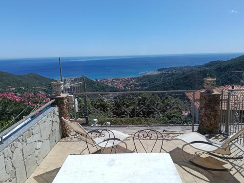 a balcony with chairs and tables and the ocean at Villa vista mare in Varazze