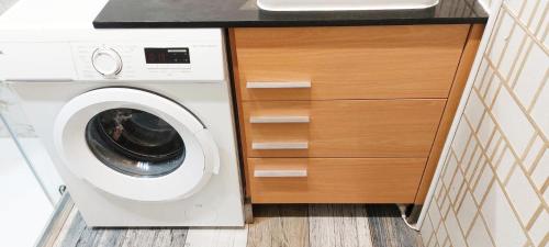 a washing machine in a kitchen with a counter at LOFT DELUXE - MADRID RETIRO in Madrid