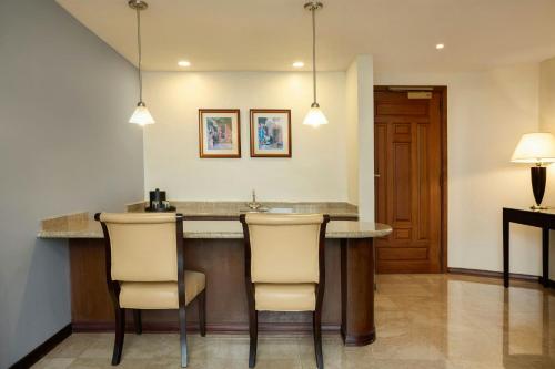 a kitchen with a bar with chairs and lights at JW Marriott Caracas in Caracas